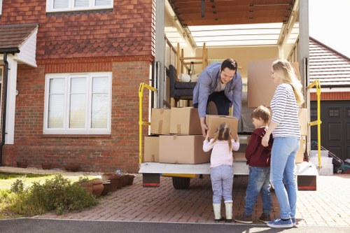 Moving team loading items safely into a van with protective equipment